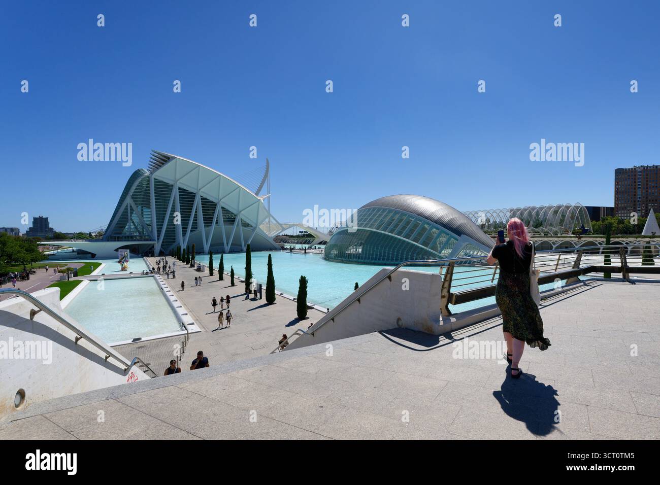 Valencia, Spagna 11 settembre 2025: Una donna con i capelli rosa che cattura la splendida architettura della città delle Arti e delle Scienze di Valencia (Ciutat de les A) Foto Stock