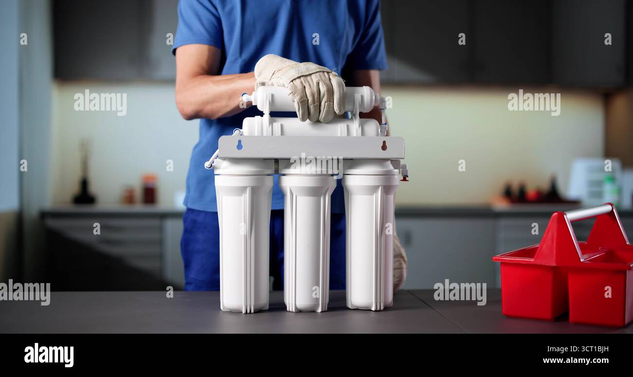 Senior Plumber installazione del sistema di filtraggio dell'acqua nelle tubazioni per cucine pulite. Foto Stock