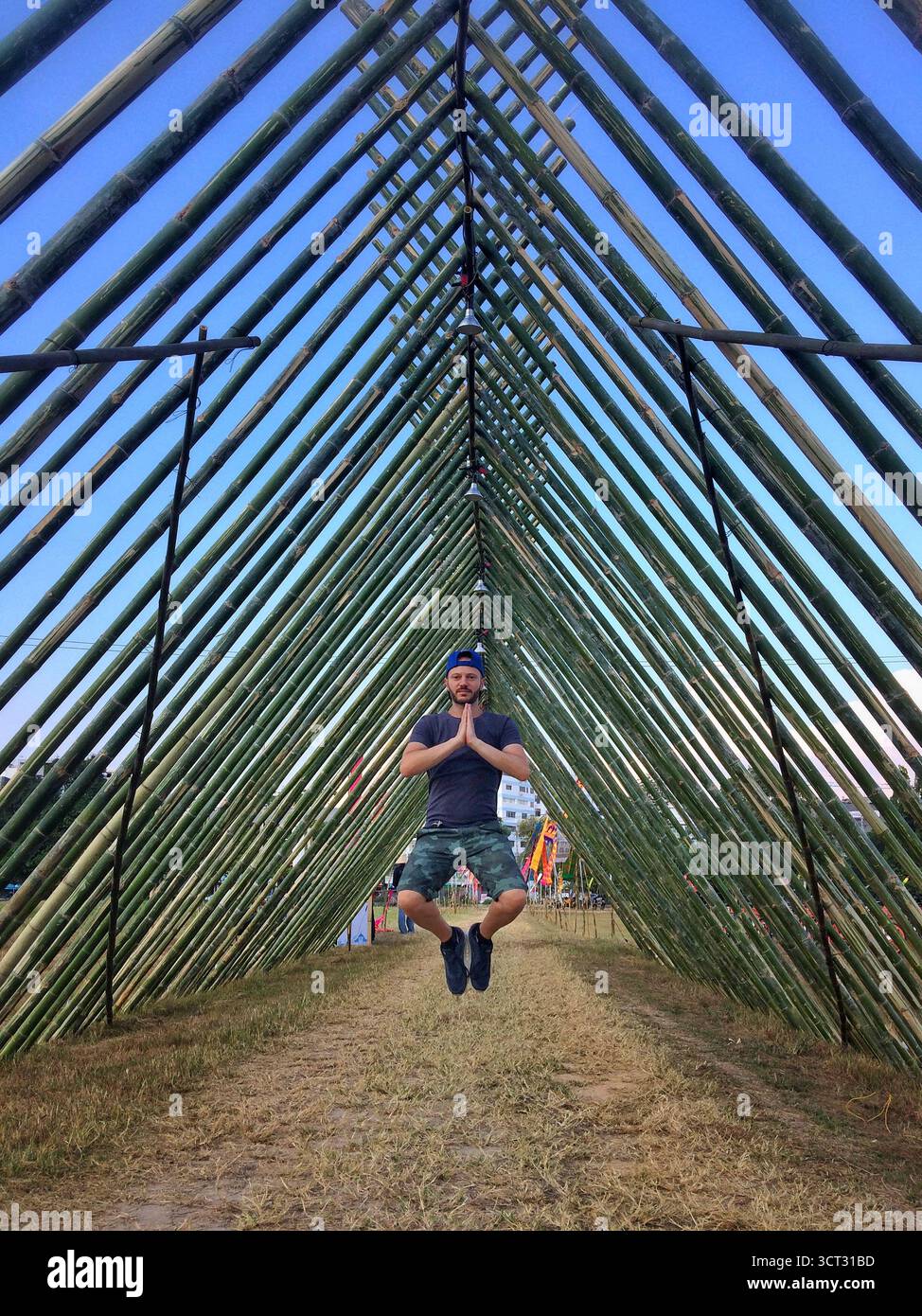 Persona che levita in posa di preghiera all'interno della struttura del tunnel di bambù, Chiang mai, Thailandia - 5 dicembre 2018. Foto Stock