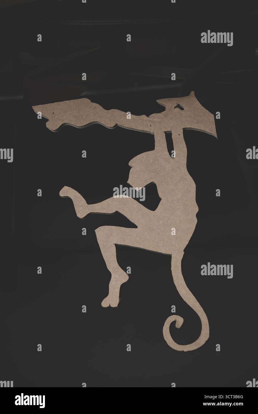 Sagoma di una scimmia appesa a un tronco ad albero Foto Stock