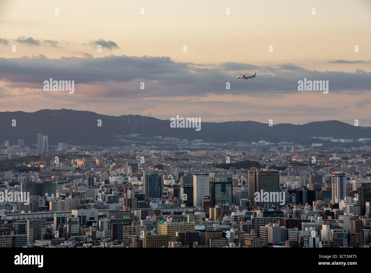 Aereo che sorvola lo skyline di Osaka al tramonto, Giappone Foto Stock