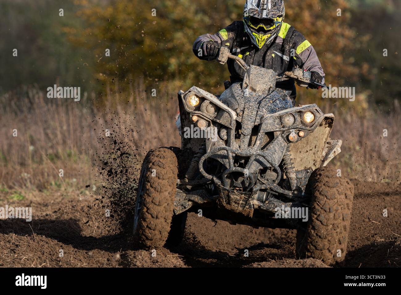 Un quad pieno di fango durante una gara enduro Foto Stock