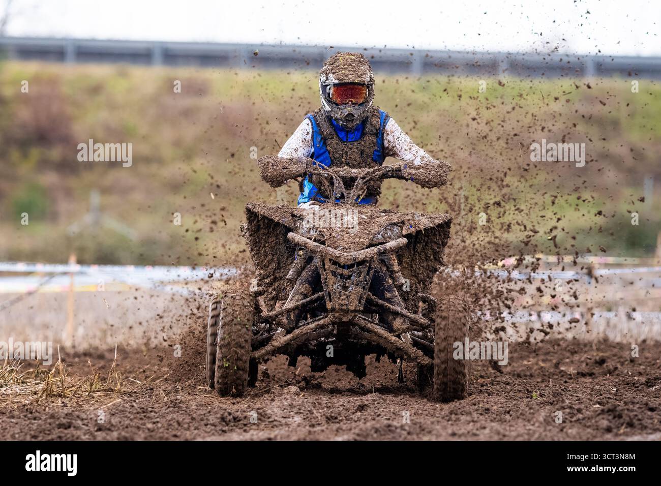 Un quad su un circuito pieno di fango Foto Stock