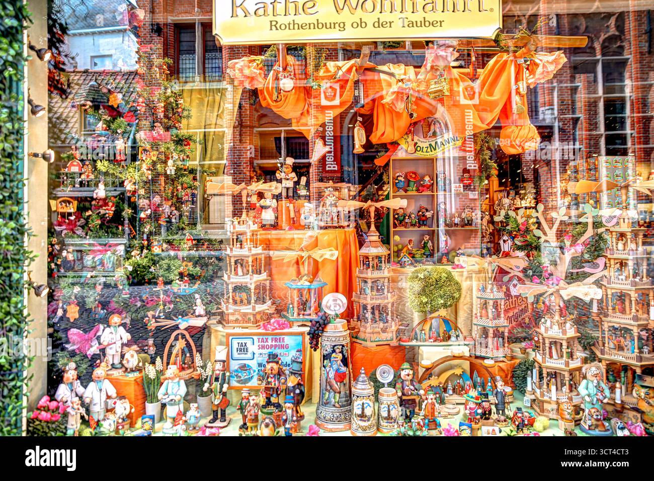 Vetrina colorata del negozio di caramelle e cioccolato a Bruges piena di dolci, decorazioni e vivaci confezioni arancioni Foto Stock