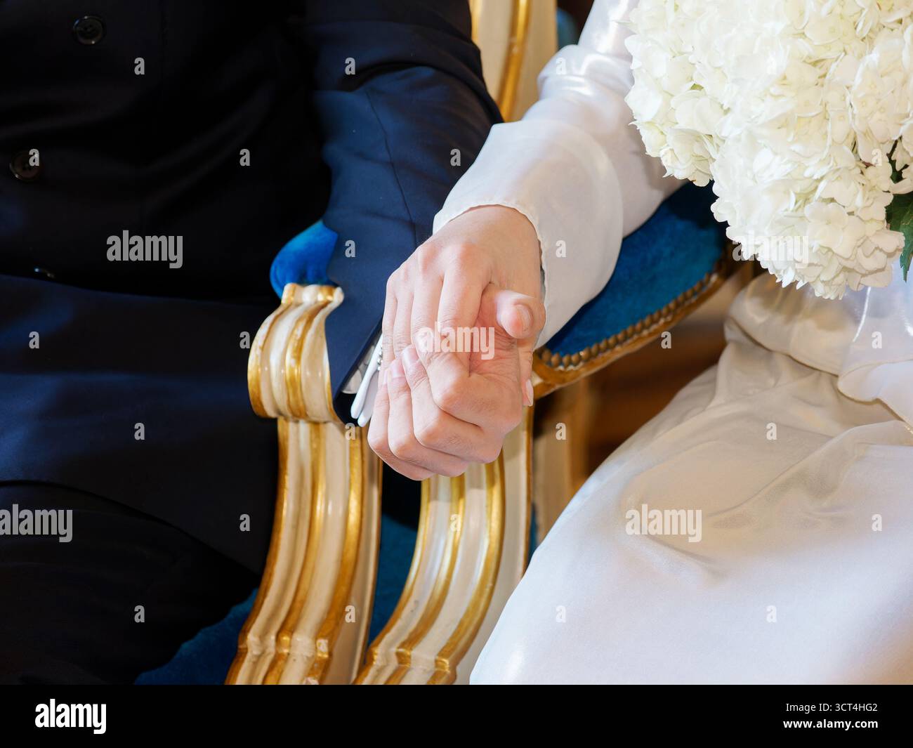 Sposa e sposo che si tengono per mano durante la cerimonia nuziale, simbolo di amore, unità ed emozione. Foto Stock