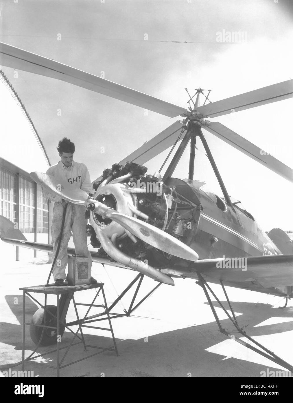 Meccanico che lavora sul motore di un prototipo di aereo-copter Gyro Foto Stock