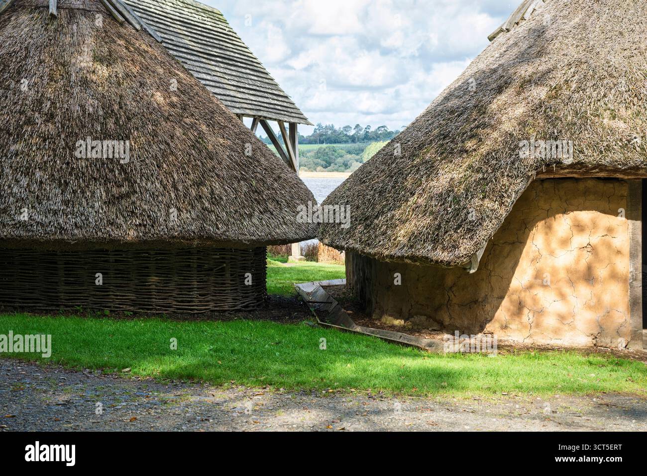 Vista a livello dell'occhio di un insediamento vichingo con case rotonde e case longhouse vicino al fiume, nel primo pomeriggio autunnale. Foto Stock