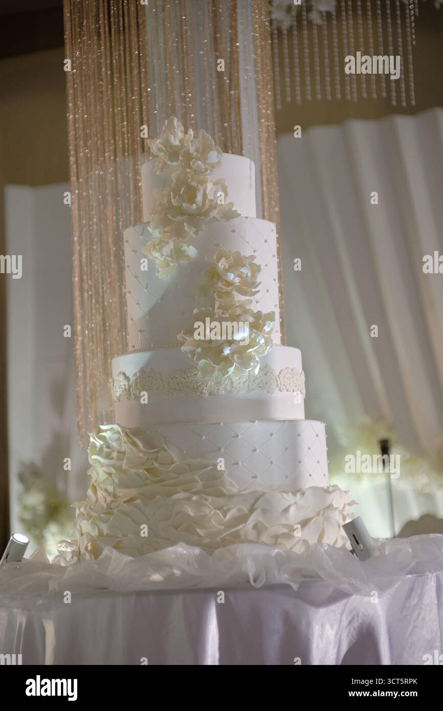 Una grande torta nuziale con decorazioni di lusso rappresenta lo splendore dell'evento per una coppia felice. Foto Stock