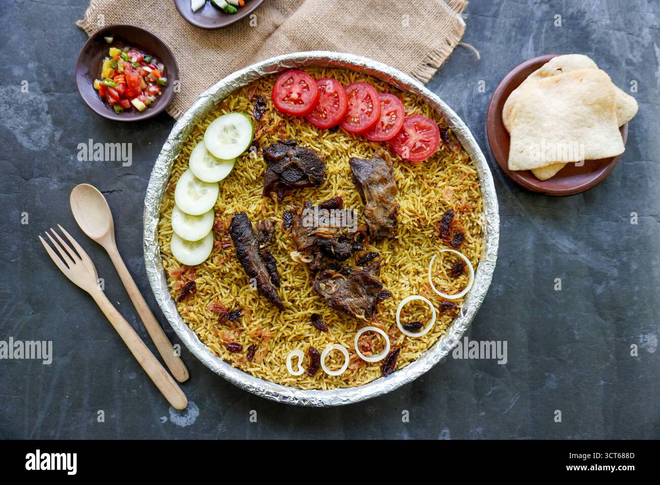 Riso Kebuli tradizionale con agnello, cucina aromatica a base di riso speziato, servito con carne tenera, uvetta, cetriolo, cipolla, condimento e pomodoro fresco sl Foto Stock