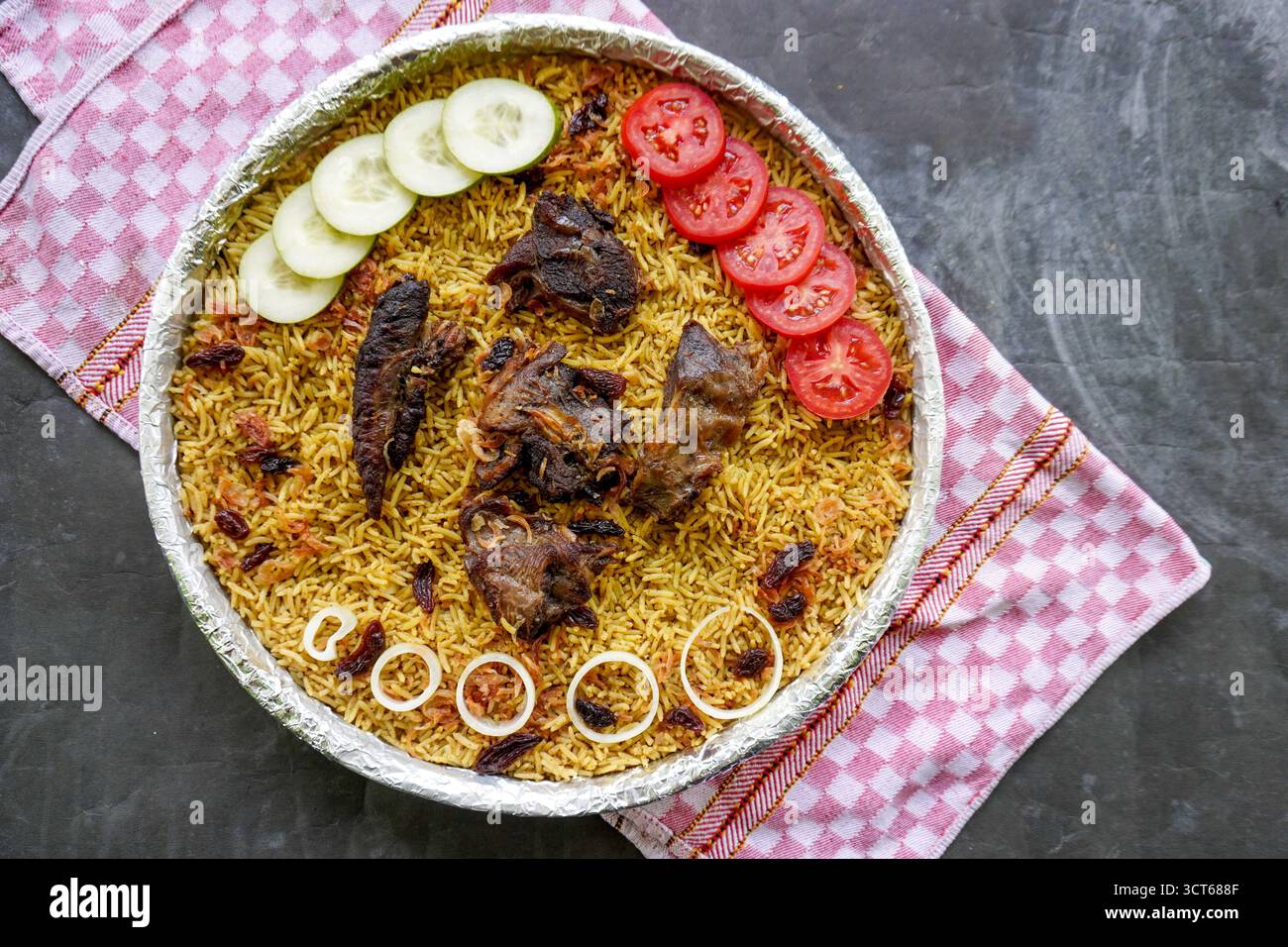 Riso Kebuli tradizionale con agnello, cucina aromatica a base di riso speziato, servito con carne tenera, uvetta, cetriolo, cipolla, condimento e pomodoro fresco sl Foto Stock