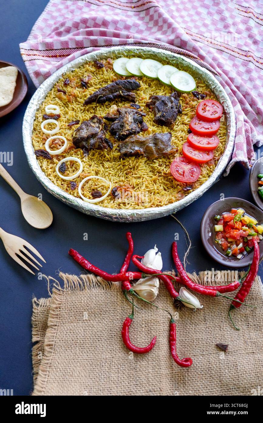 Riso Kebuli tradizionale con agnello, cucina aromatica a base di riso speziato, servito con carne tenera, uvetta, cetriolo, cipolla, condimento e pomodoro fresco sl Foto Stock