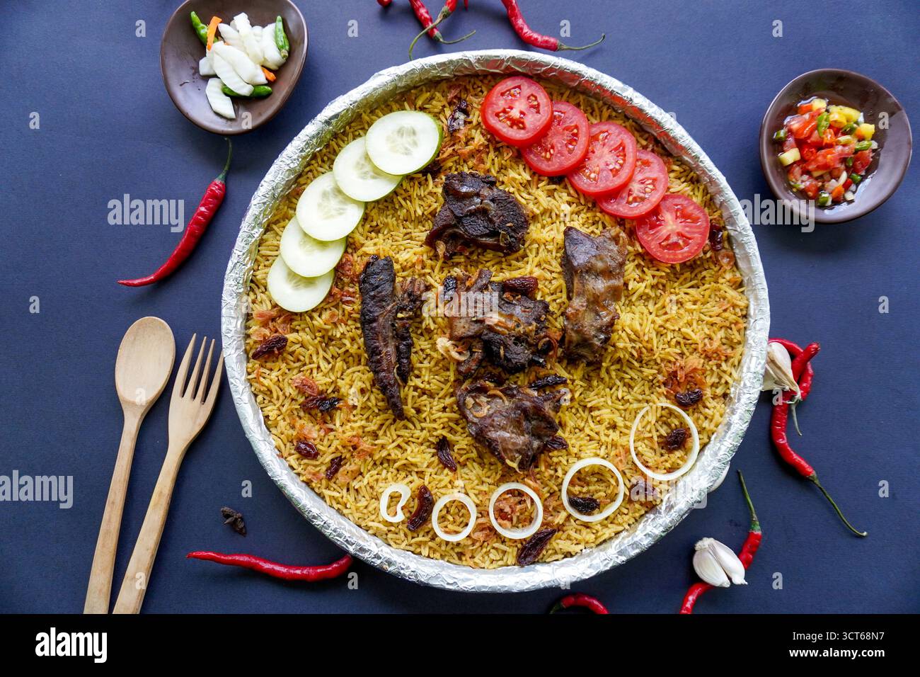 Riso Kebuli tradizionale con agnello, cucina aromatica a base di riso speziato, servito con carne tenera, uvetta, cetriolo, cipolla, condimento e pomodoro fresco sl Foto Stock