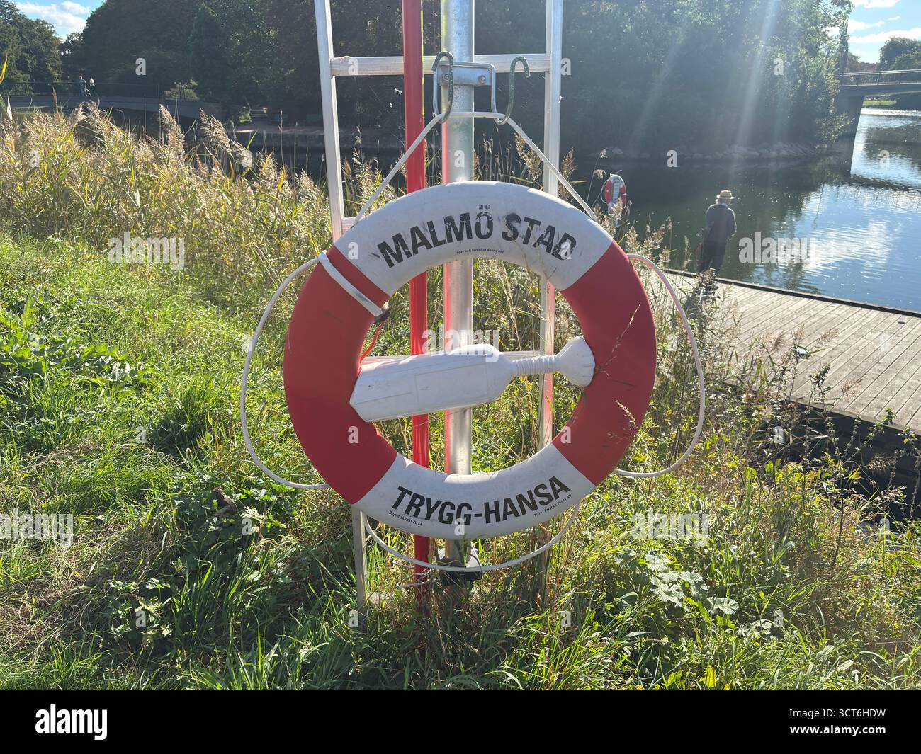 Anelli salvagente di emergenza su cavalletti posizionati accanto all'acqua in Svezia e Danimarca, compresi dispositivi galleggianti arancioni con linee collegate per il lancio Foto Stock