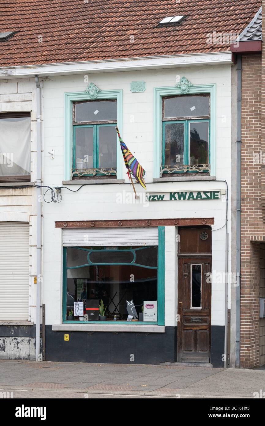 Vista frontale dell'edificio dell'organizzazione della comunità Vzw Kwaazie con bandiera colorata appesa alla finestra nel centro di Leopoldsburg Foto Stock
