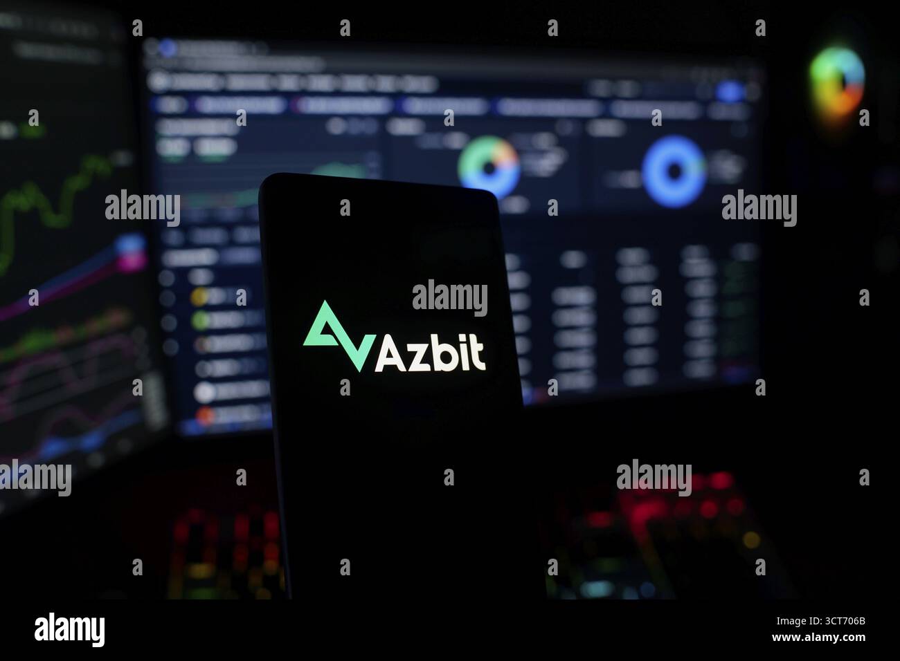 Smartphone con logo Azbit su schermi commerciali poco illuminati Foto Stock