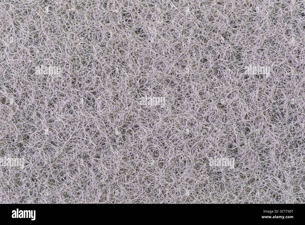 Vista macro della superficie della trama dello strato di spugna scrubber da cucina nera e dello sfondo. Foto Stock