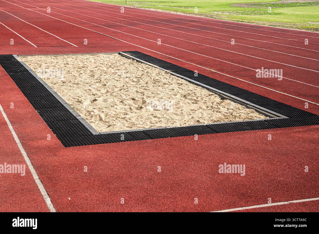 Lungo salto di sabbia, pista e campi da golf nello stadio Foto Stock