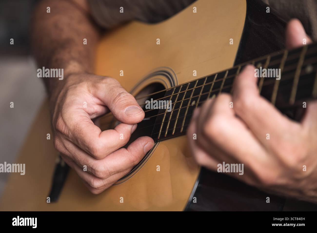 Un vecchio musicista occasionale che impara a suonare la chitarra acustica in salotto, concetto di pratica domestica. Messa a fuoco selettiva. Foto Stock
