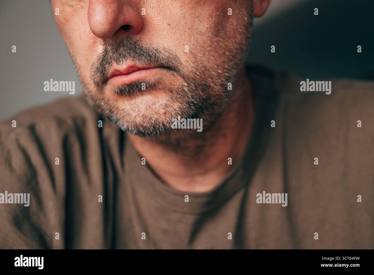 Primo piano di un uomo adulto maturo con barba corta ed espressione seria, dettagli del viso ritagliati, umore premuroso e introspettivo. Messa a fuoco selettiva. Foto Stock