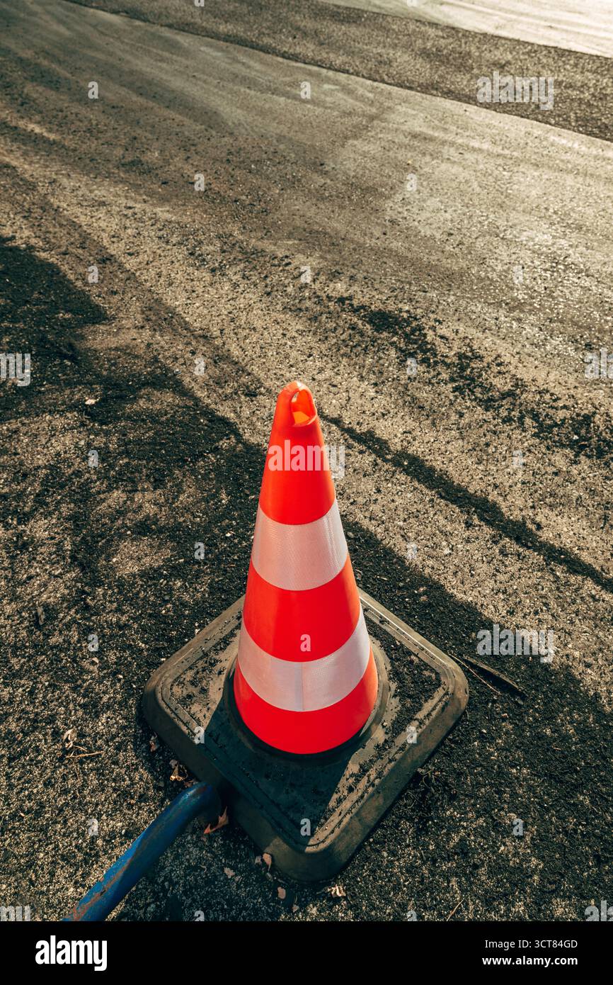 Cono stradale su asfalto contrassegnato con piste di scorrimento e fumo degli pneumatici dopo la deriva mostrano prestazioni. Messa a fuoco selettiva. Foto Stock