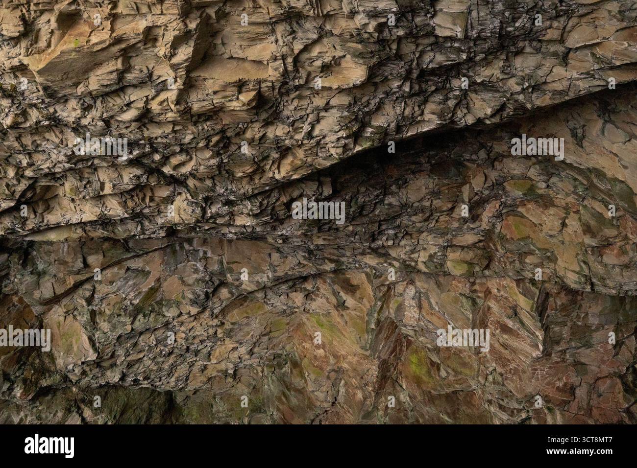 Parete rocciosa intemprata che mostra stratificazione geologica naturale e modelli di erosione Foto Stock