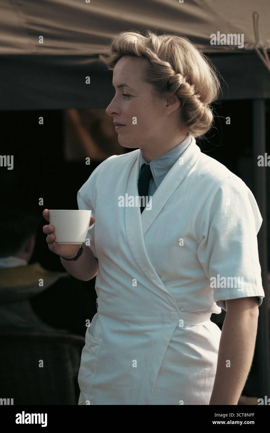 infermiera degli anni '1940 in uniforme d'epoca godendo di una pausa tè durante la rievocazione in tempo di guerra Foto Stock
