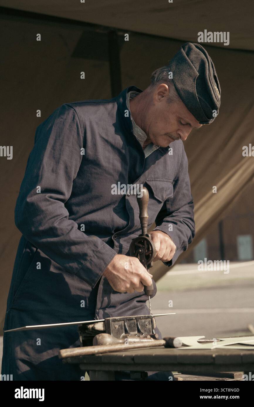 Artigiano tradizionale che utilizza una pialla manuale su legno in un'officina d'epoca Foto Stock