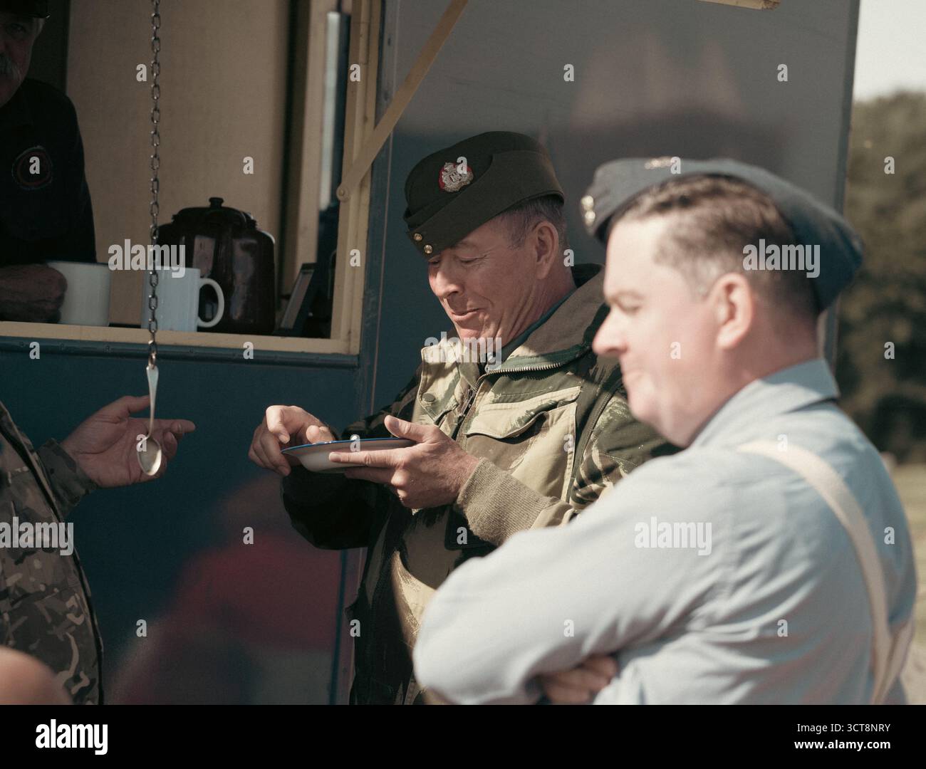 Rievocatori della seconda guerra mondiale in uniformi militari del periodo gustando rinfreschi durante lo storico evento dell'aviazione Foto Stock