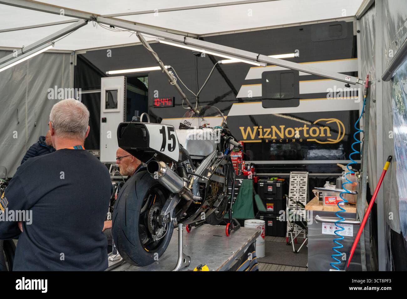 Meccanici motociclistici che lavorano in garage paddock da corsa con numero 15 di moto Foto Stock
