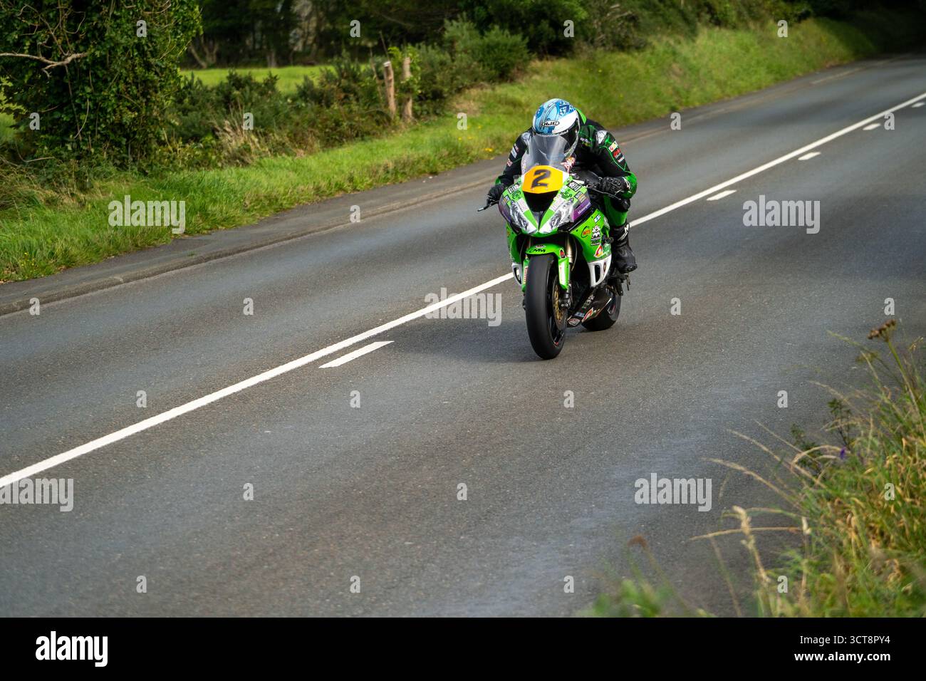 Corse di motociclette in velocità attraverso la campagna sul campo TT dell'Isola di Man Foto Stock