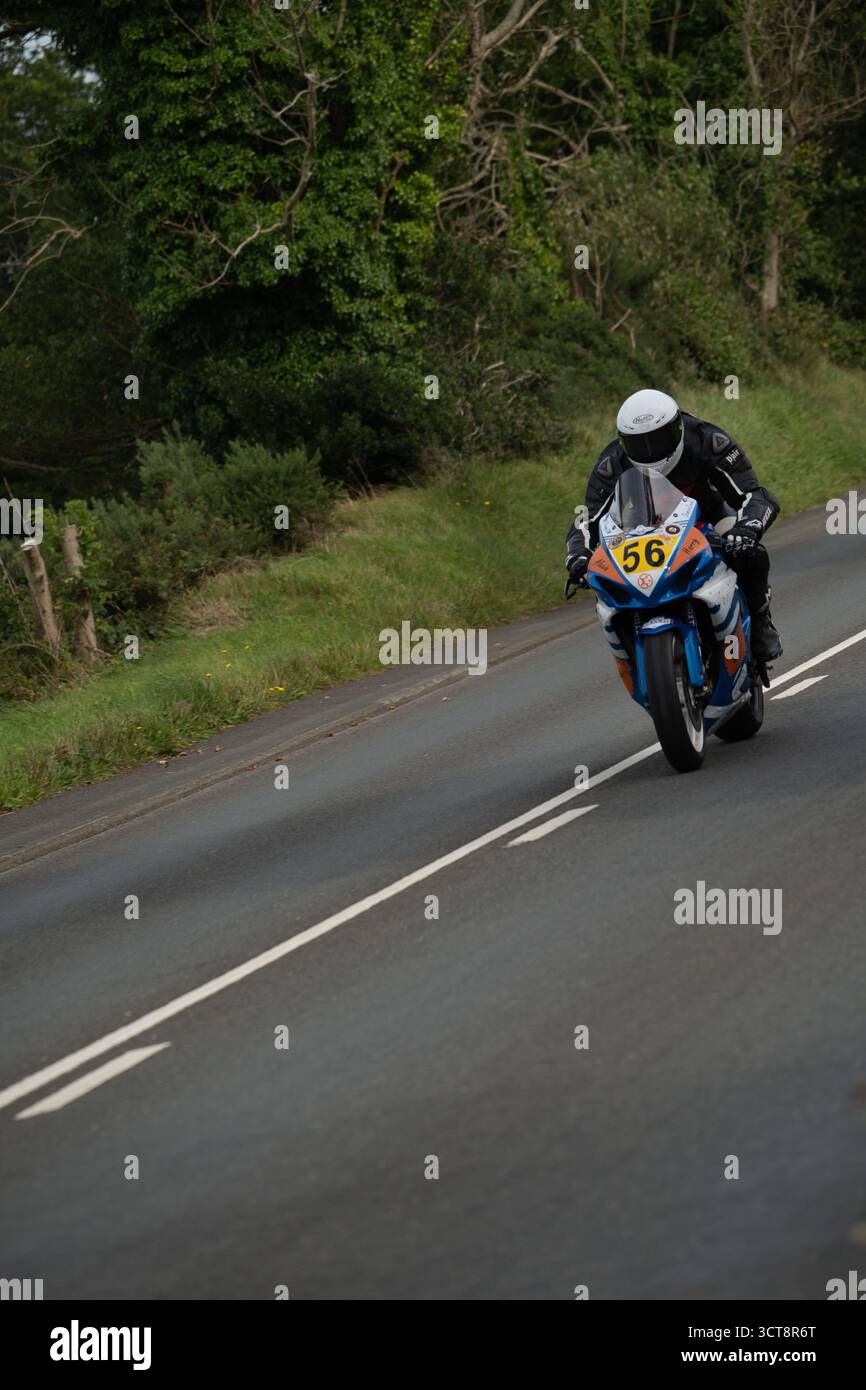 Motociclista numero 56 su strada di campagna attraverso la verde campagna durante il TT dell'Isola di Man Foto Stock