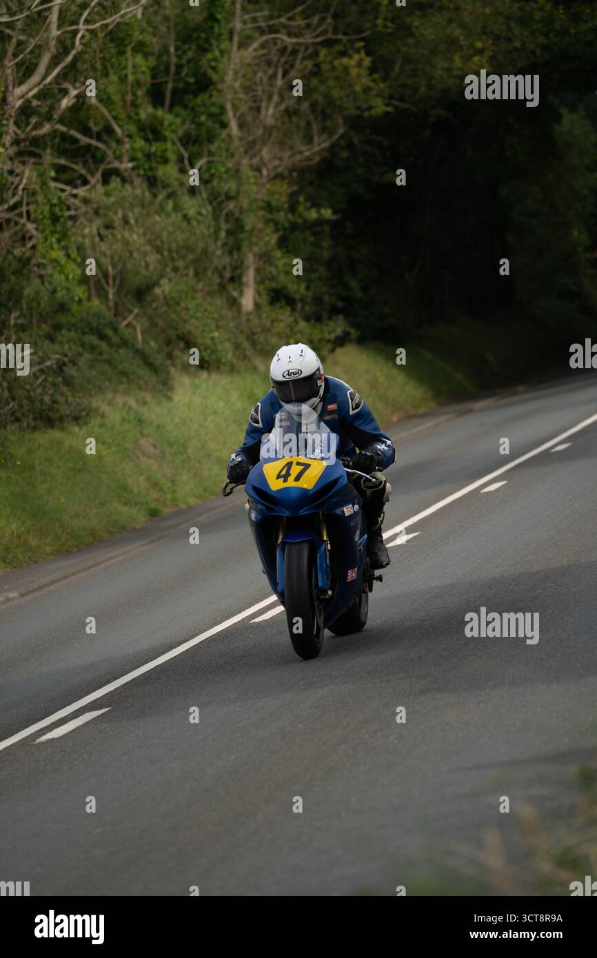 Motociclista numero 47 sul circuito stradale dell'Isola di Man con sfondo di campagna Foto Stock