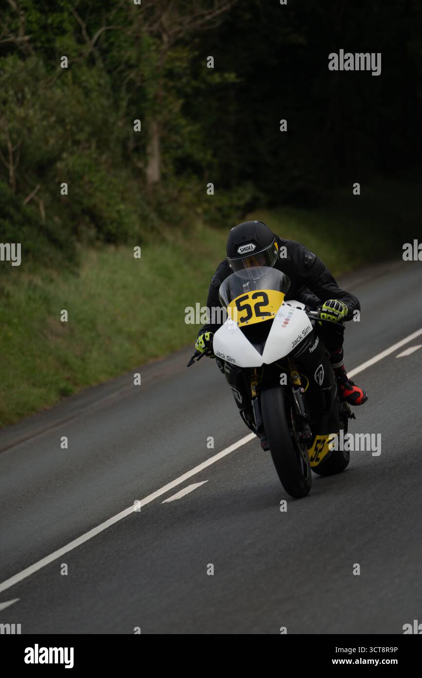 Moto da corsa numero 52 dietro l'angolo sul campo TT dell'Isola di Man Foto Stock
