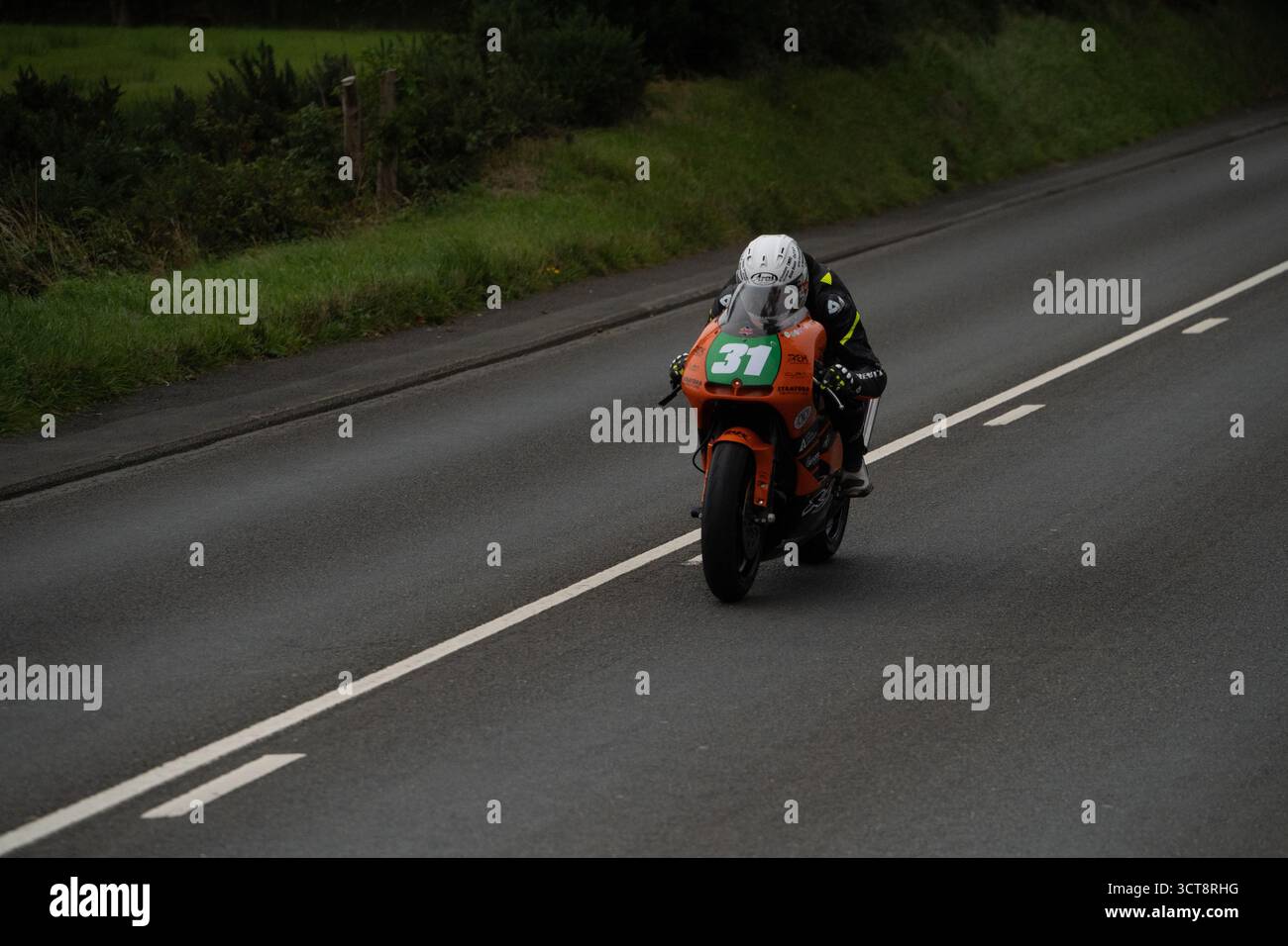 Motociclista numero 31 su moto arancione durante le gare TT dell'Isola di Man Foto Stock