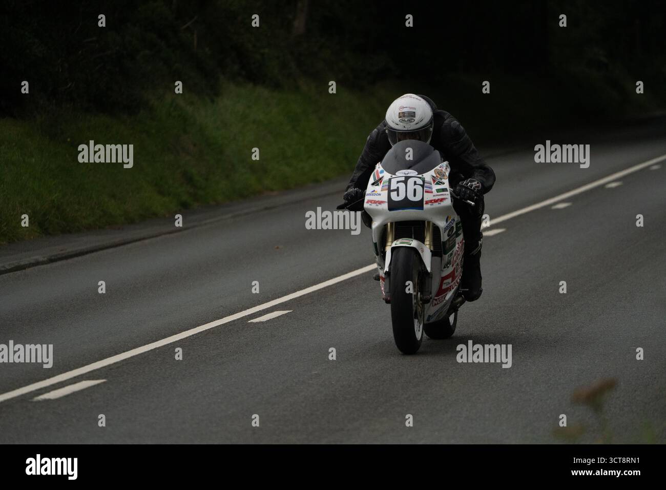 Moto da corsa numero 56 sul campo TT dell'Isola di Man con pilota in posizione di gara Foto Stock