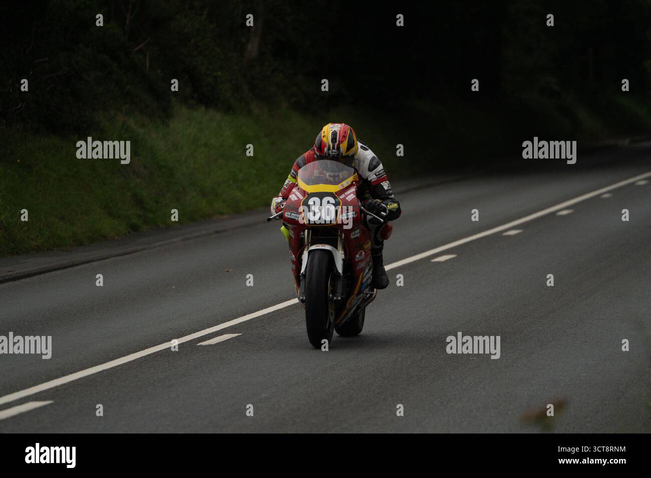 Moto da corsa numero 36 in accelerazione sul campo TT dell'Isola di Man con piloti in pelle da corsa Foto Stock