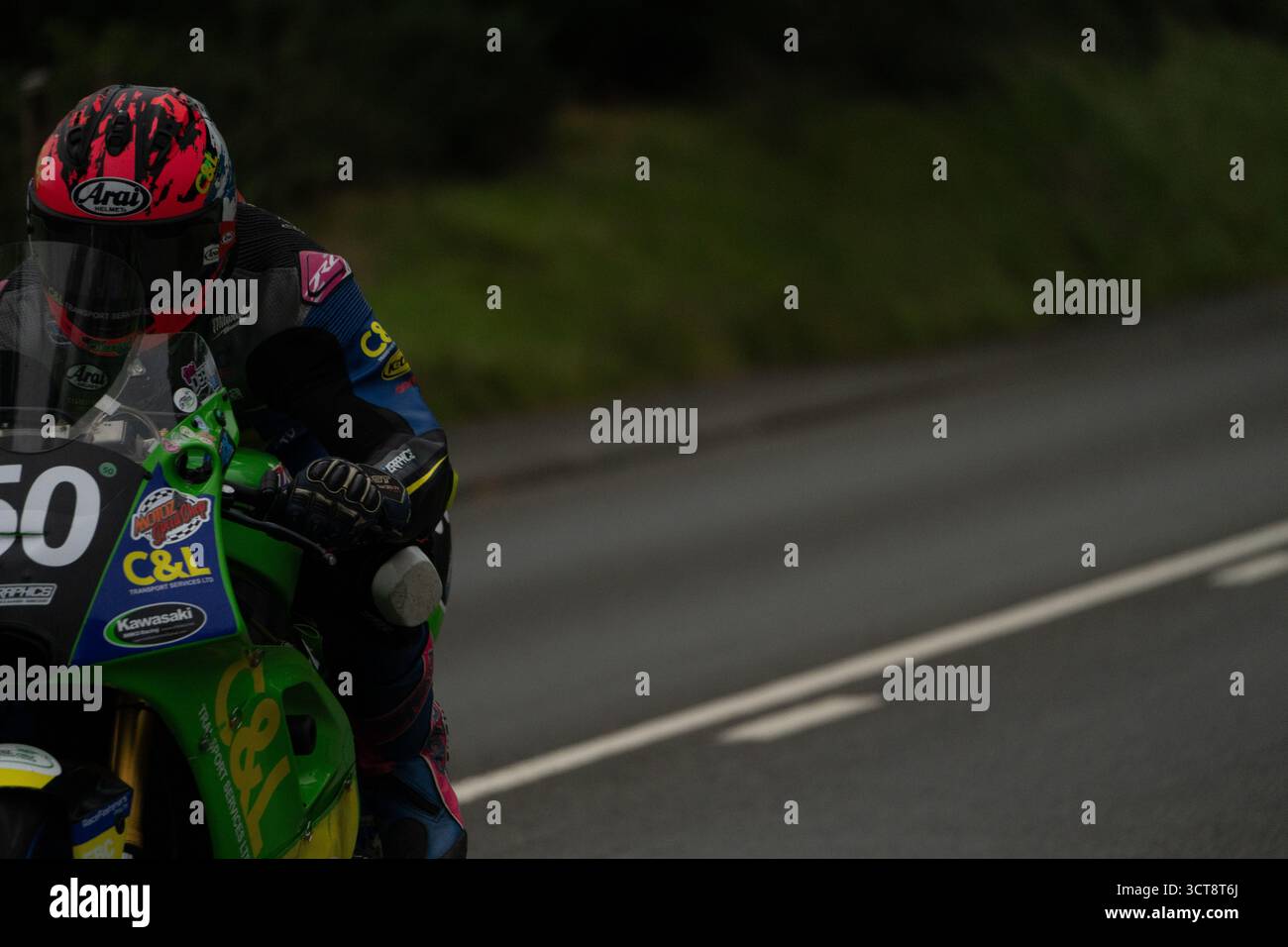 Motociclisti che gareggiano sul campo TT dell'Isola di Man con moto Kawasaki verde Foto Stock