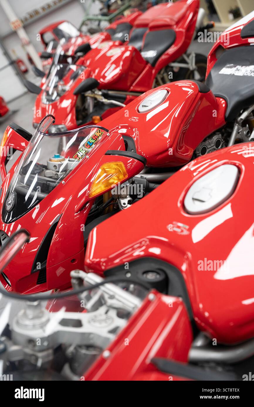 Moto da corsa rosse in garage pit Lane durante le gare TT dell'Isola di Man Foto Stock