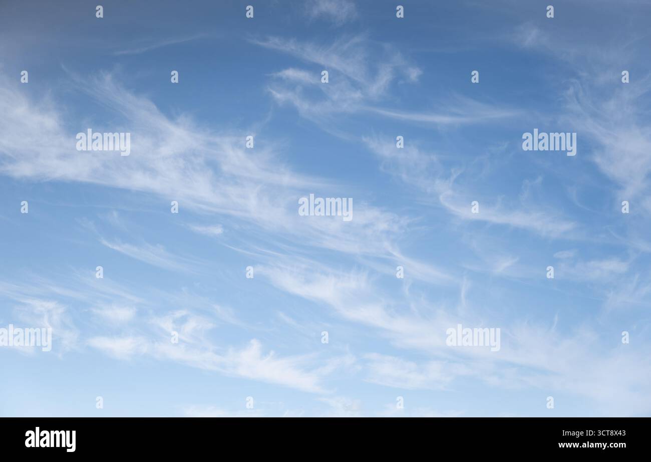 Nuvole bianche striscianti che attraversano il cielo estivo azzurro del Northumberland Foto Stock
