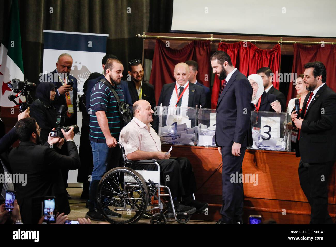 La Siria tiene le prime elezioni parlamentari da Assads Fall Damasco, Siria, 5 ottobre 2025: Il presidente siriano Ahmed al-Sharaa incontra un elettore con disabilità in un seggio elettorale durante le prime elezioni parlamentari siriane dalla caduta del regime di Assad. Damasco Siria Copyright: XMohammadxBashirxAldaherx Foto Stock
