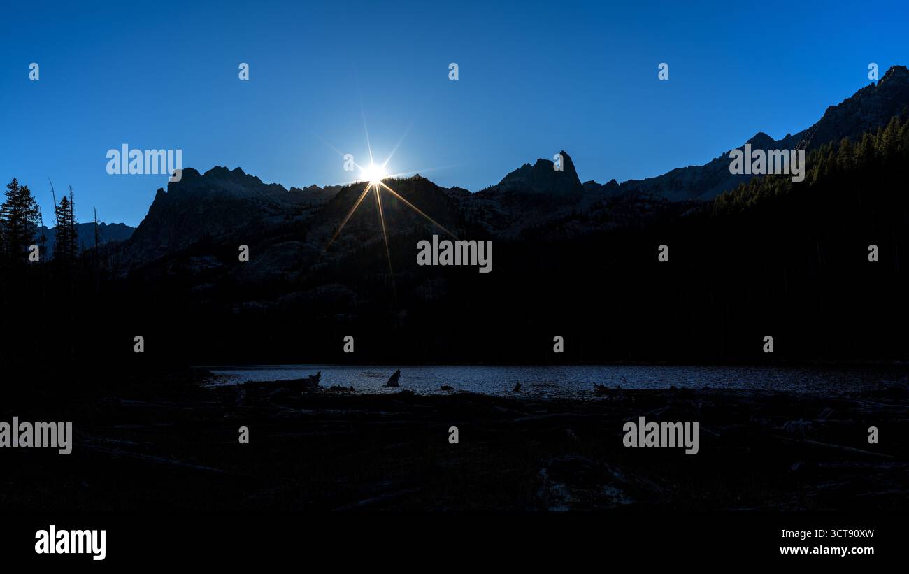 Sunstar sgorga sulle cime delle montagne nella natura selvaggia dell'Idaho Foto Stock
