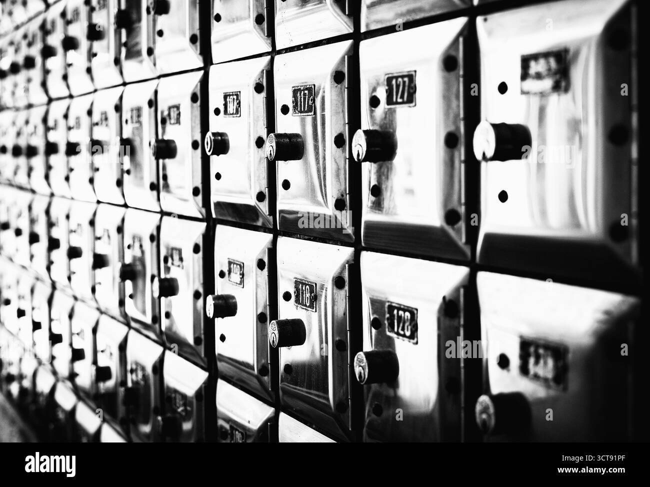 Un muro pieno di file di vecchie cassette di valore in metallo lucido Foto Stock