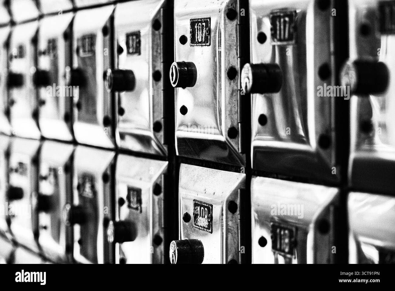 Un muro pieno di file di vecchie cassette di valore in metallo lucido Foto Stock