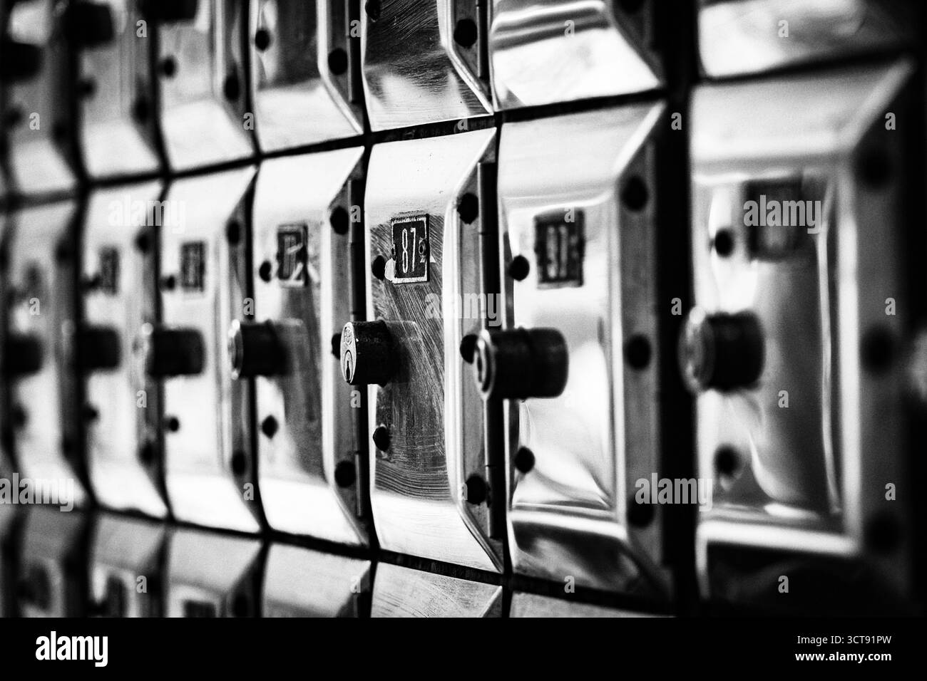 Un muro pieno di file di vecchie cassette di valore in metallo lucido Foto Stock