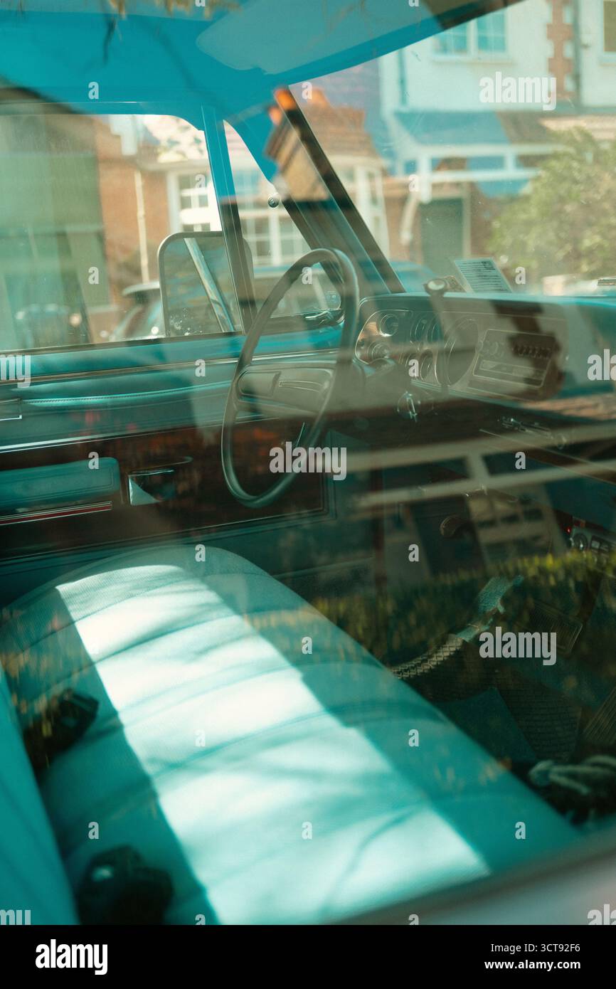 Chiswick, Londra – 2025.04.28 – interni di un camion Dodge d'epoca visto attraverso la finestra, che cattura i sedili turchesi, il volante e il classico Foto Stock