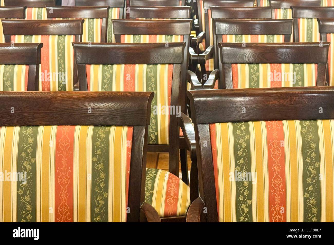 Tappezzeria a righe su sedie in legno Vintage con toni caldi e motivi classici. Concetto di design di mobili tradizionali, tendenze tessili, Styl per interni Foto Stock