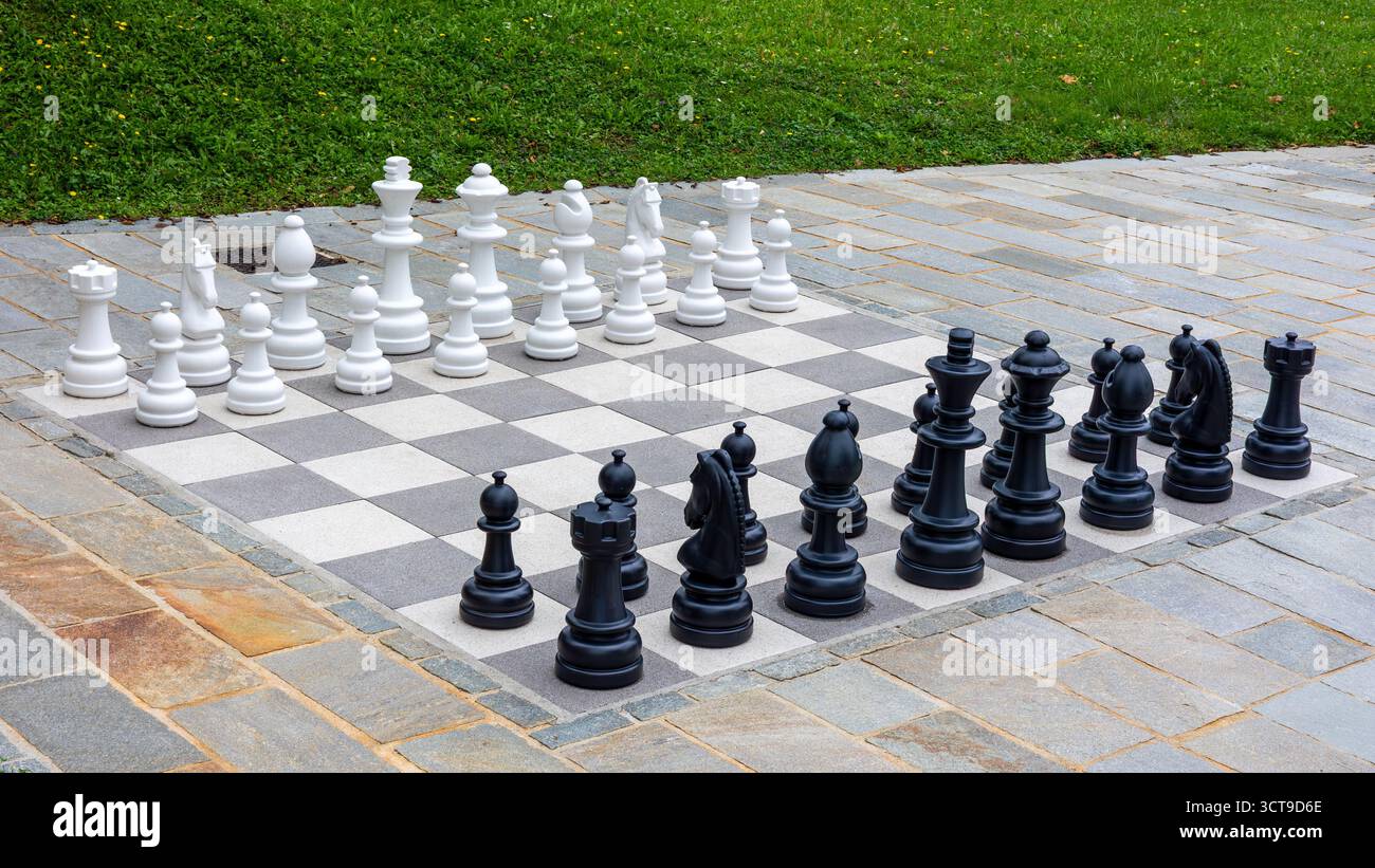 Scacchi giganti all'aperto su Stone Plaza pavimentata con pezzi in bianco e nero Foto Stock