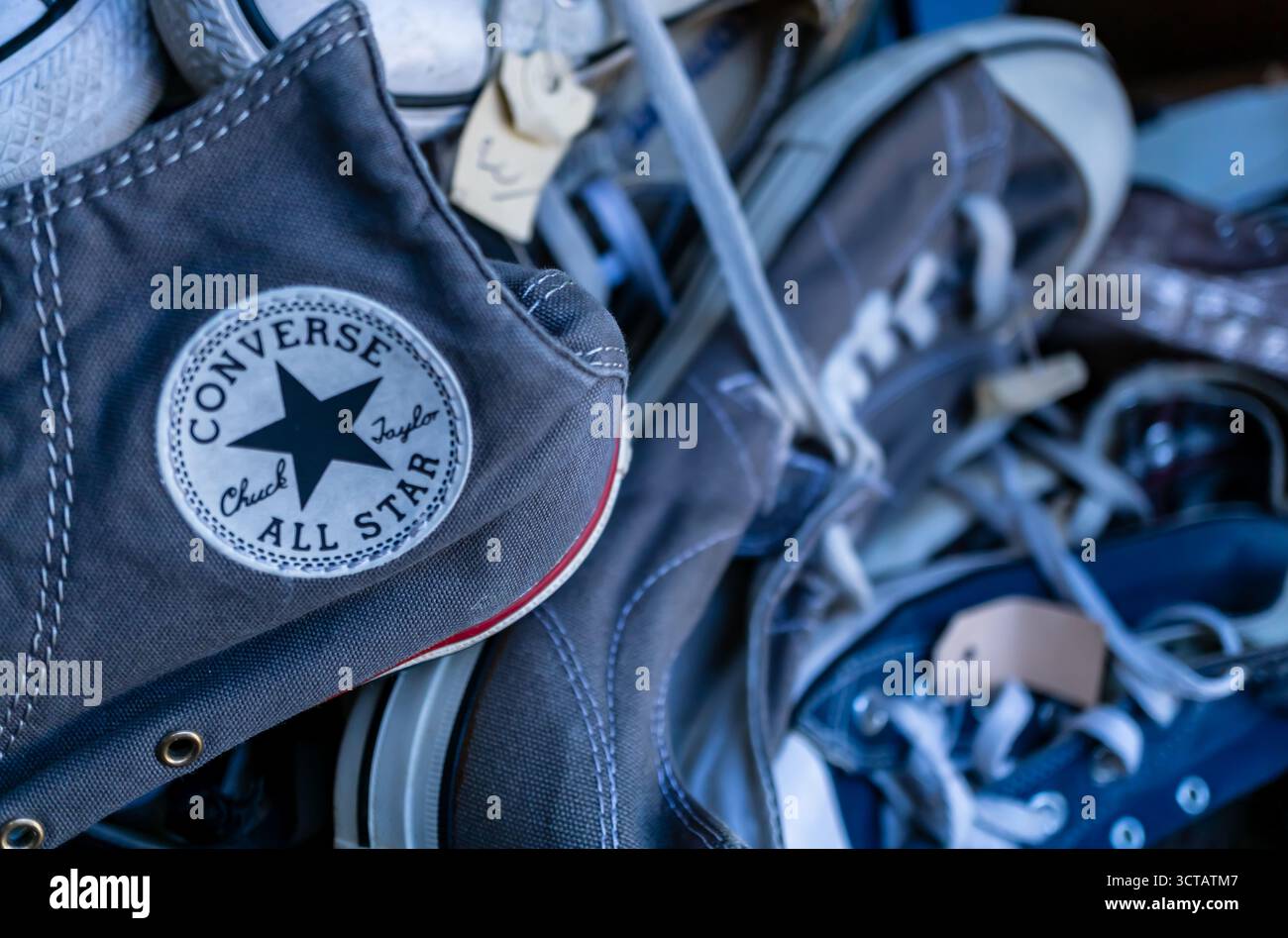 Primo piano di sneakers Converse All Star vintage esposte in un negozio di seconda mano a Berlino, simbolo della cultura della moda casual. Foto Stock