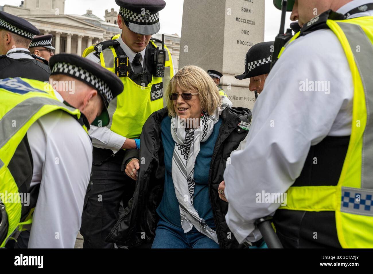Protesta contro l'azione palestinese. Una donna anziana viene arrestata per avere in mano il cartello "io sono contrario al genocidio, sostengo l'azione palestinese”. Londra Regno Unito Foto Stock