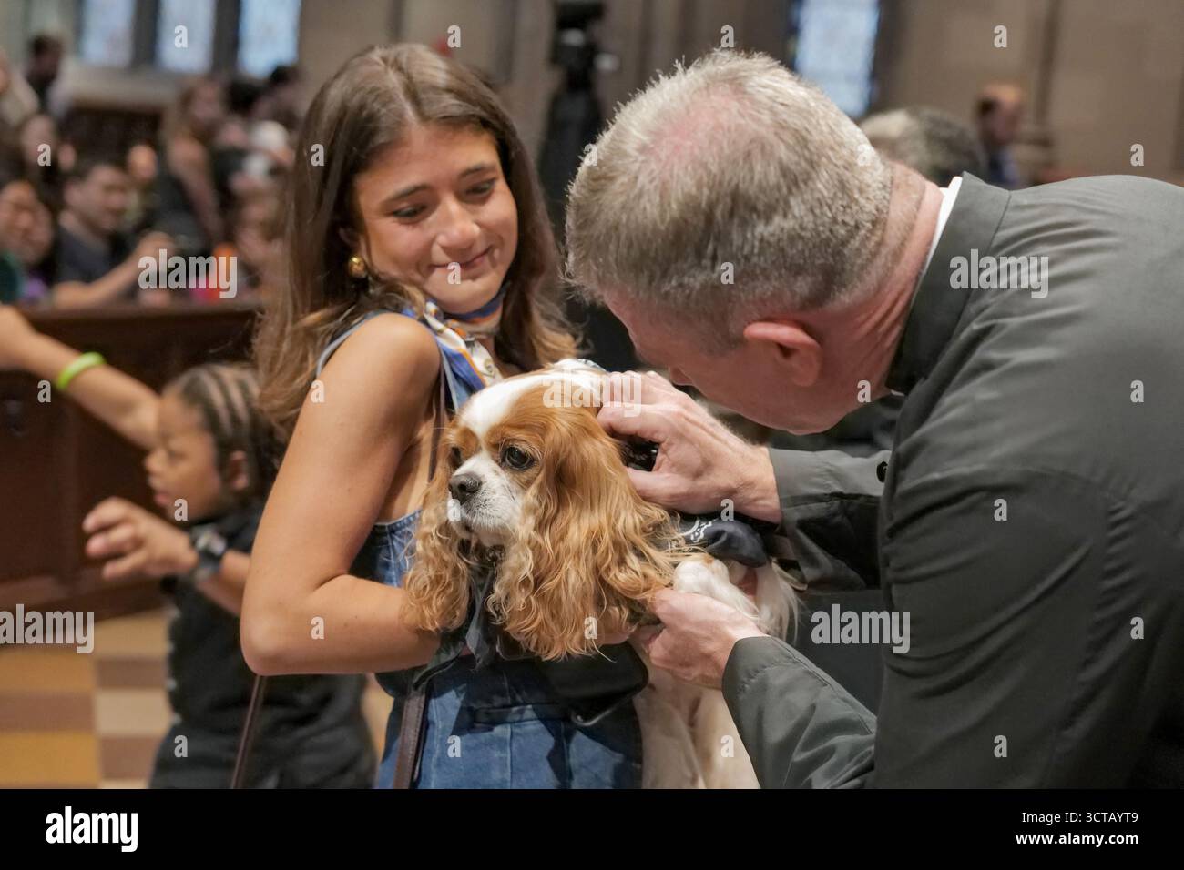 New York, New York, Stati Uniti. 5 ottobre 2025. Era tutto a portata di mano all'annuale Trinity Church Blessing.of the Animals. La parrocchia episcopale di Lower Manhattan rendeva omaggio alla vita di San Francesco, il santo patrono. Di animali che benedicono cani, gatti, tartaruga e camaleonte. Clero.benedetto ogni animale mani sopra con compassione e amore. Vicario. Il Rev. Michael A. Bird qui benedice uno spaniel. Crediti: ZUMA Press, Inc./Alamy Live News Foto Stock
